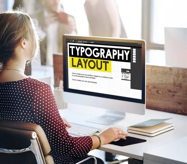 Businesswoman working on computer with typography layout