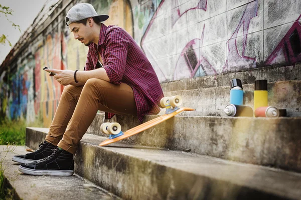Man Skateboarder looking at phone