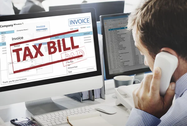 Businessman working on computer with Tax Bill