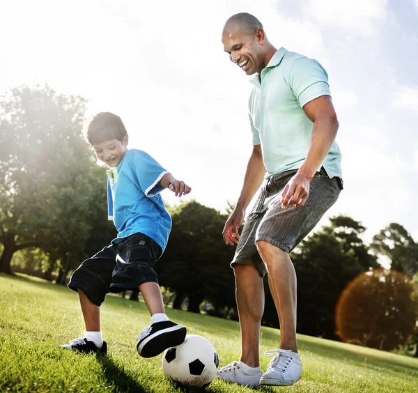 Father playing football with little son