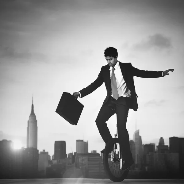 Businessman riding one wheel bicycle