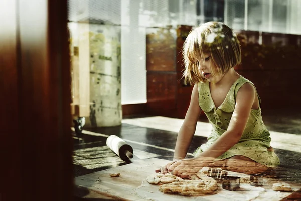 Girl kneading dough for cookies