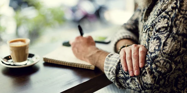 Man writing notes in cafe