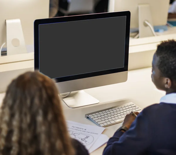 Classmate pupils using computer
