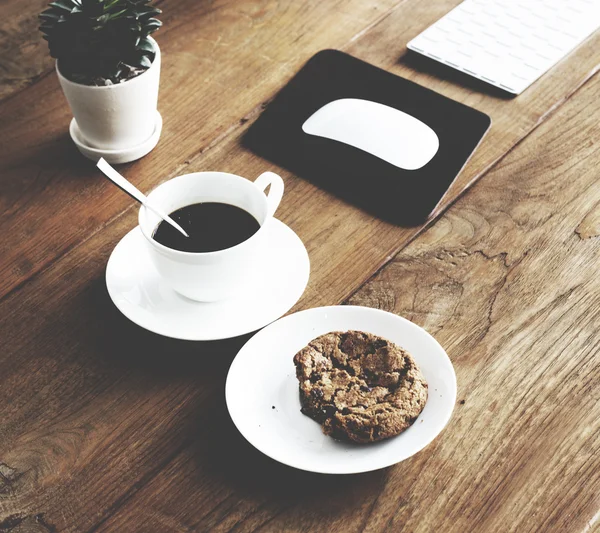 Coffee and biscuit on table.