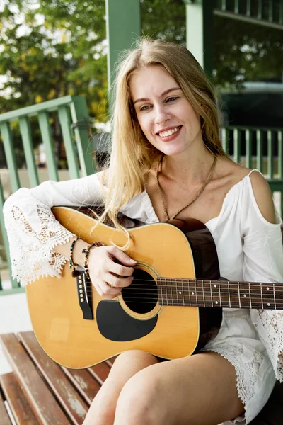 Cute Girl playing on Guitar outdoors