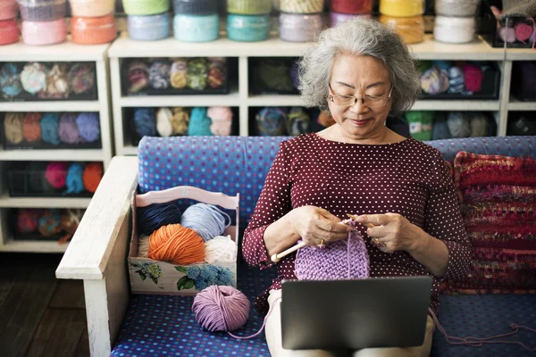 Elderly woman Knitting Scarf