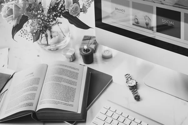 Computer and opened book on desk