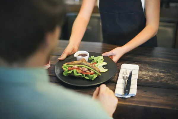 Barista with food at cafe