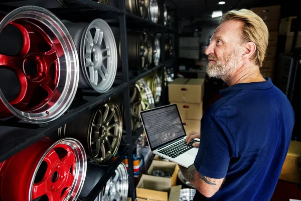 Car mechanic with laptop in Garage