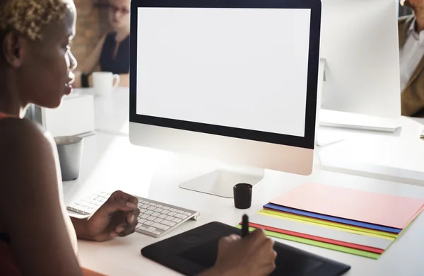 Businesswoman working on computer with blank monitor