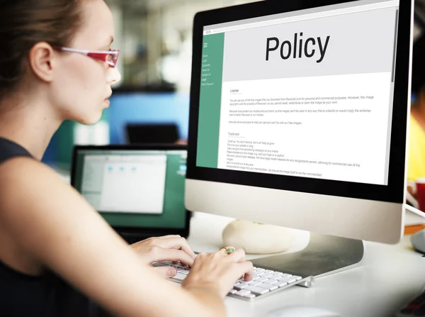 Businesswoman working on computer with Policy
