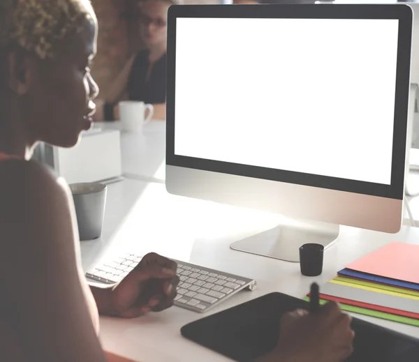 Businesswoman working on computer with white monitor