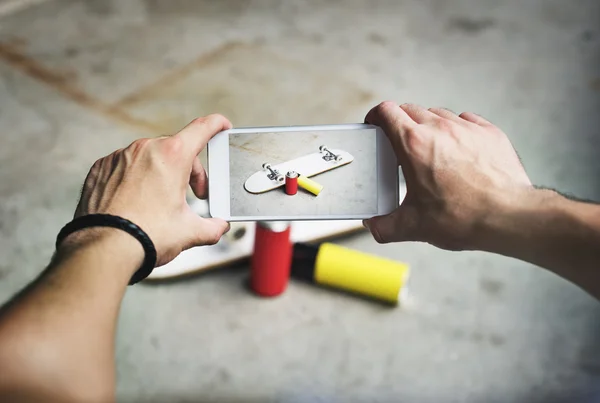 Skateboarder man holding smart phone