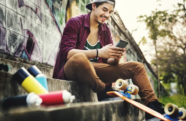 Skateboarder man holding smart phone