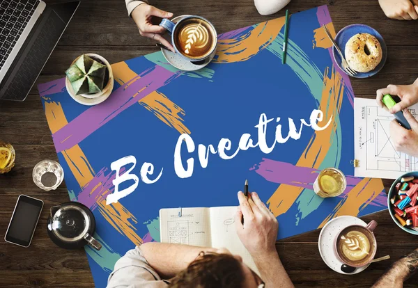 Table with poster with Be Creative concept