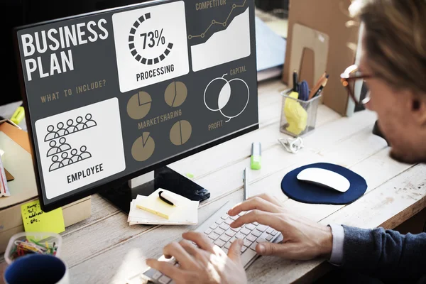 Businessman working on computer with business plan