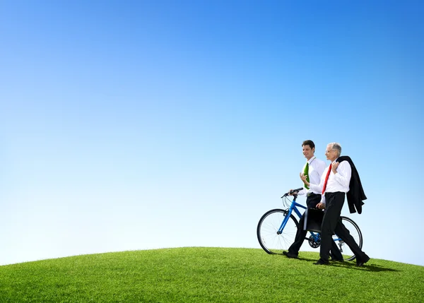 Businessmen Walking with a Bicycle