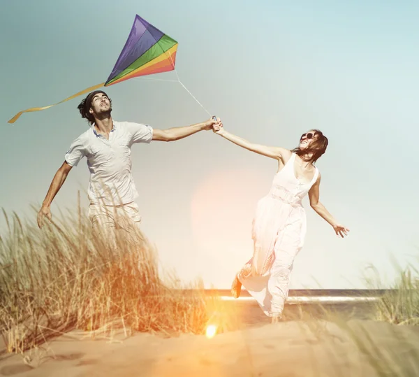 Couple at Beach Holiday Flying Kite Concept