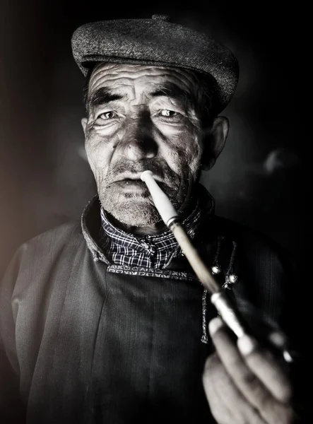 Mongolian Man Smoking a Pipe
