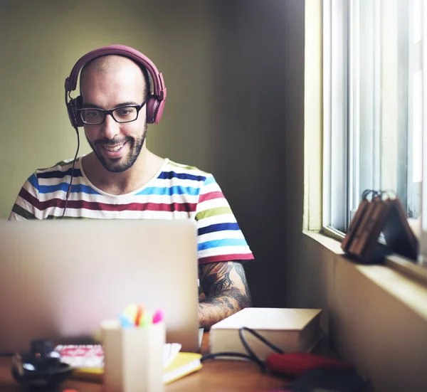 Man with headphones working on laptop computer