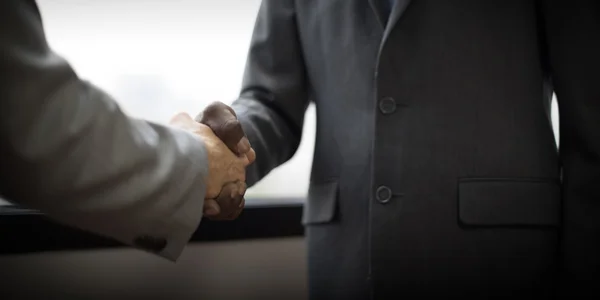Business people handshaking to confirm deal