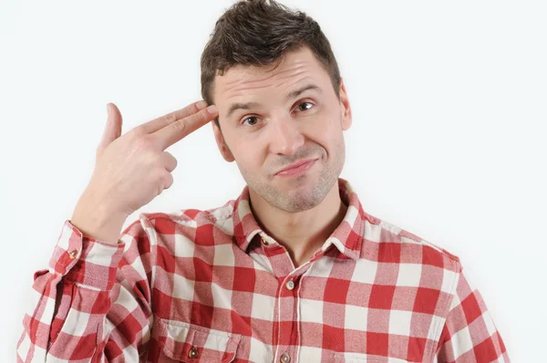 Young emotional woman with a finger to her temple like a gun  on white background