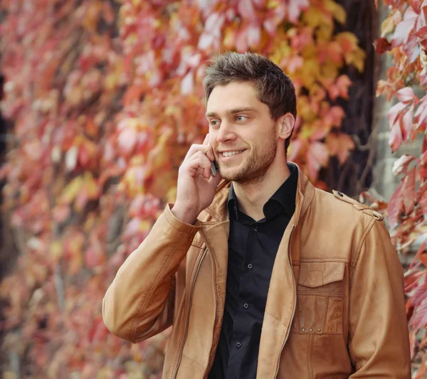 Portrait of attractive stylish young man speaking on the phone i