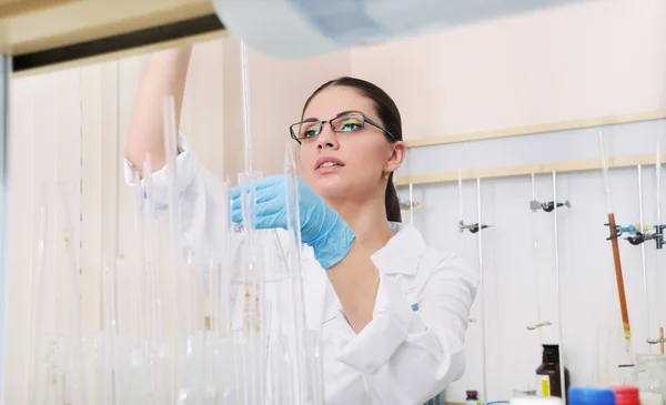 Young woman scientist in glasses working at the laboratory