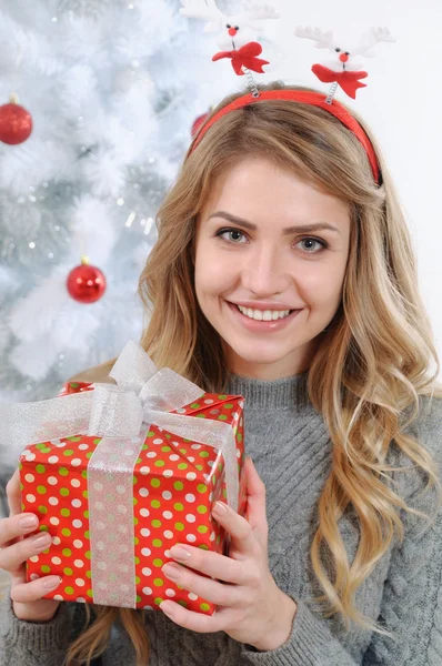 Portrait of an attractive young woman with a gift for Christmas