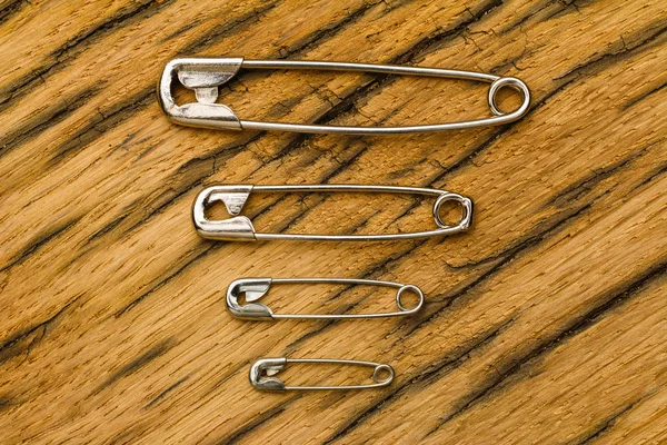 Safety pins small to big on wood