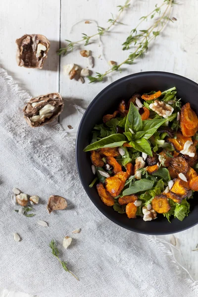 Alternative vegan salad with rocket, carrots chips, walnuts and seeds in japanese bowl
