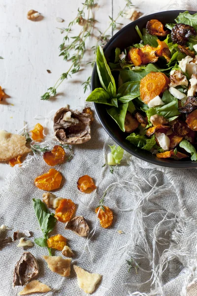 Alternative vegan salad with rocket, carrots chips, walnuts and seeds