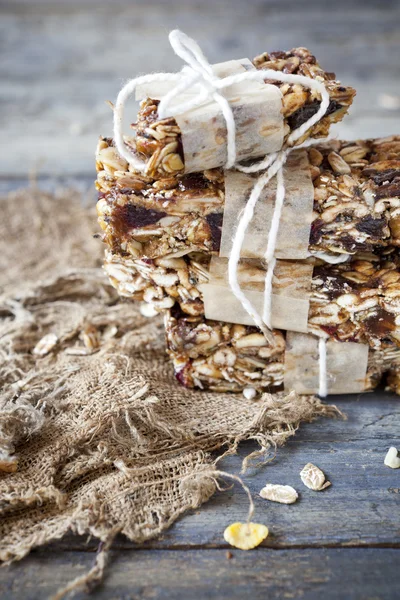 Stack of homemade granola bars with dried fruits and handmade packaged on vintage table