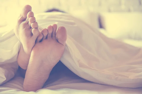 Close up feet of women sleeping women on bed