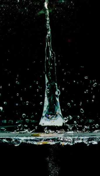 Water splash in water, isolated on black background