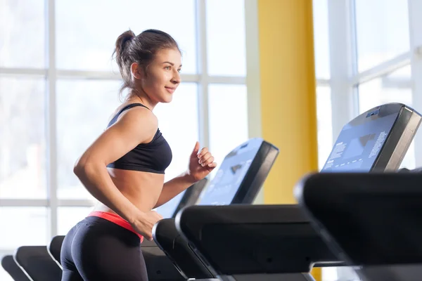 Woman runs on a treadmill at the gym