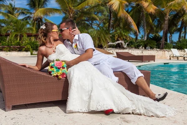 Husband and wife relaxing on sunbeds at the beach