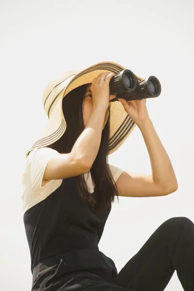 Pretty Asian young  woman seeking Binoculars .