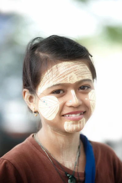 Woman with thanaka on her face in Myanmar.