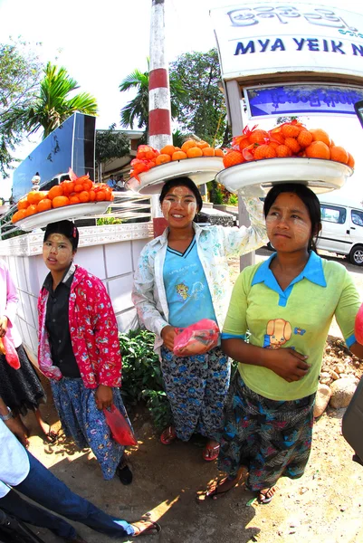Woman carrying oranges on her head for sell.