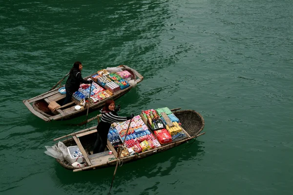 Vietnamese woman selling goods and snack on her boat.