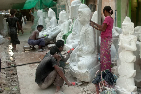 Burmese man carving and woman polishing  a large marble Buddha s