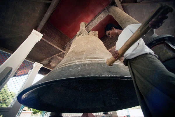 Man hitting the  Mingun bell in Myanmar.