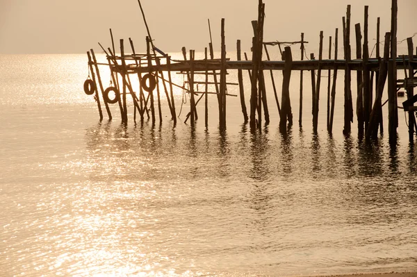 Silhouette of traditional wooden bridge on the beach.
