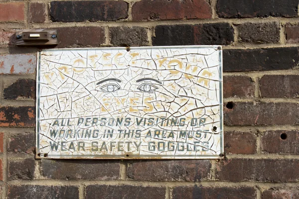 Safety googles sign on wall