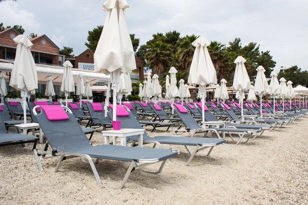 Beach umbrella and plastic deck chairs on the beach,Greek , pefk