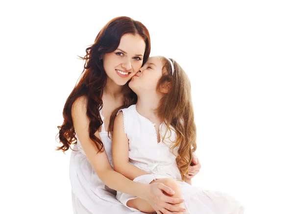 Little child daughter kissing happy mother on white background