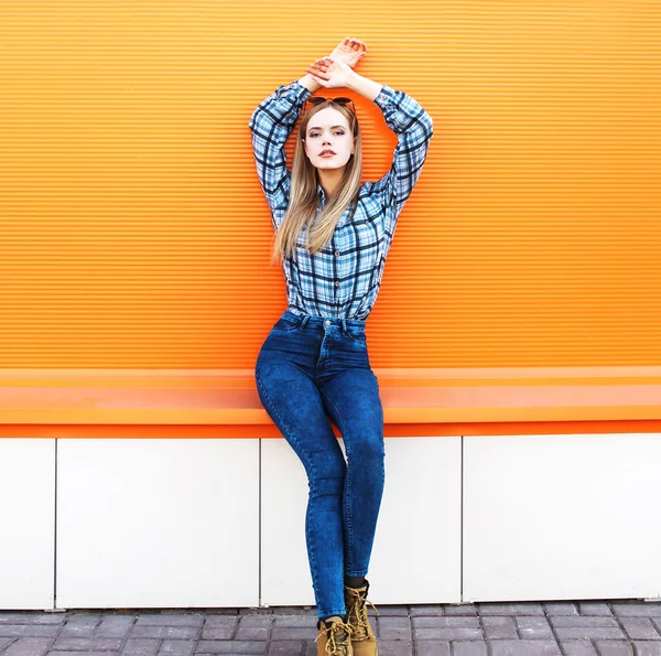 Fashion pretty blonde girl model over colorful orange background