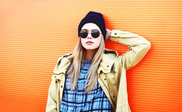 Fashion pretty blonde woman over colorful orange background